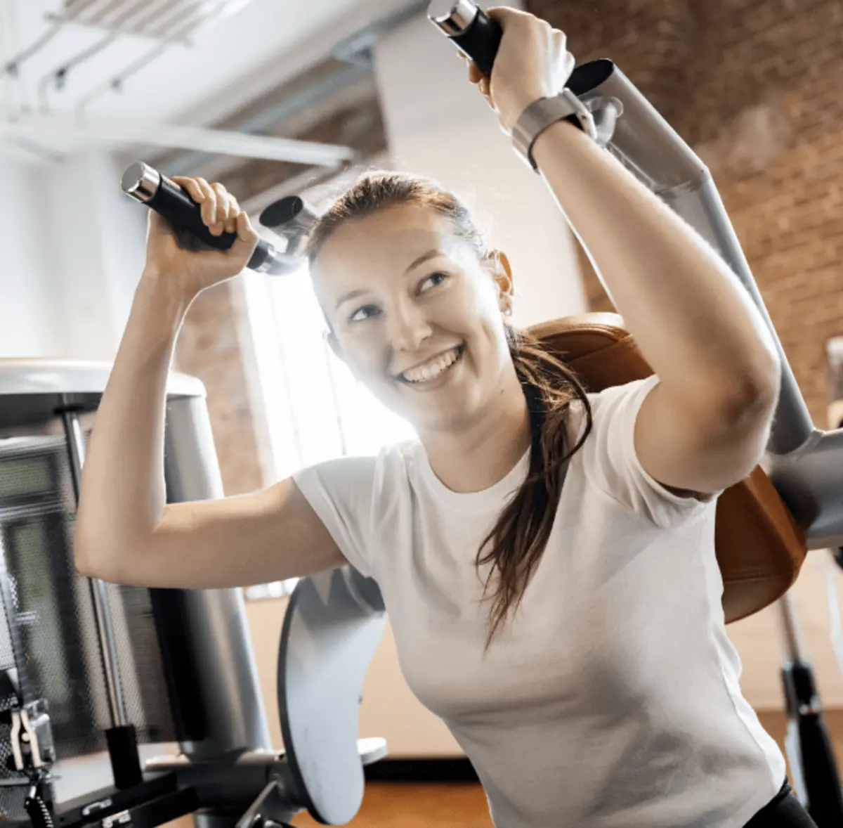 Lachende Person beim Training an einem Fitnessgerät im medicos.Osnabrück.