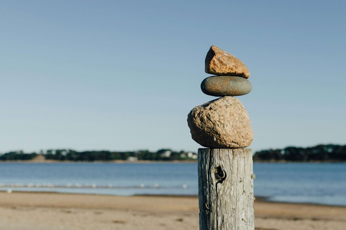 Aufeinandergestalpete Steine am Strand, die in Balance sind