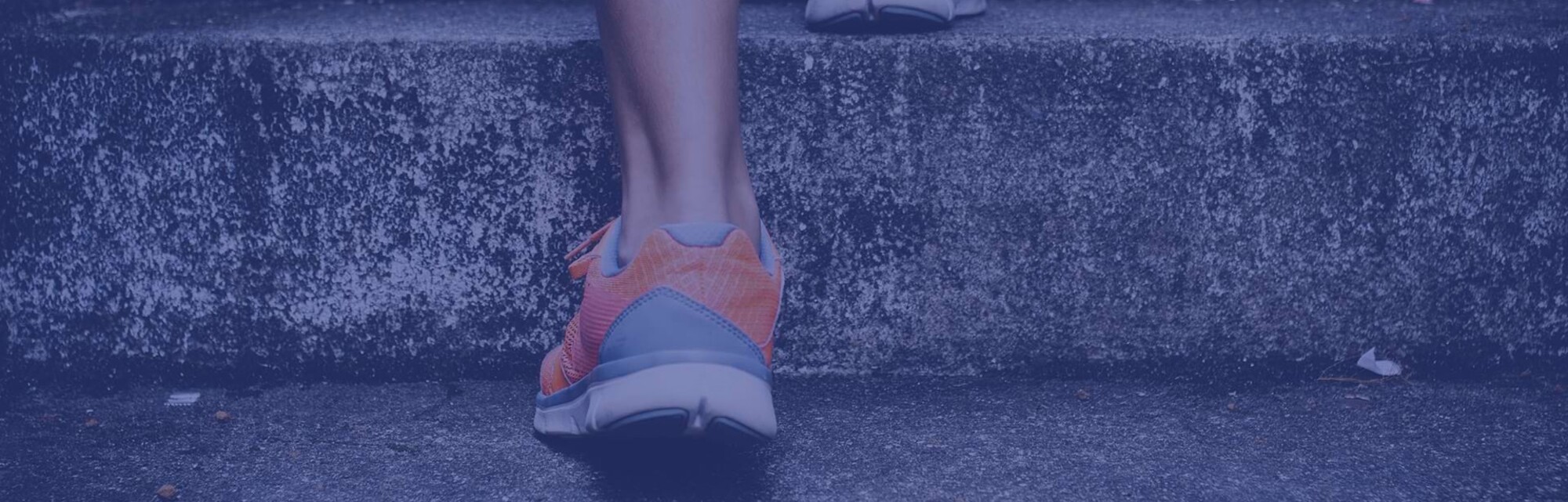 Detailaufnahme einer Person mit Sportschuhen, die die Treppe hinaufrennt