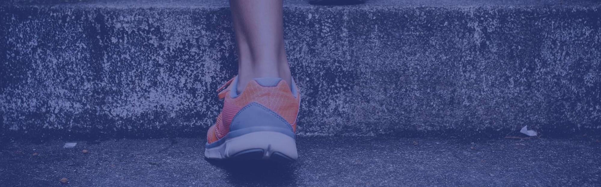 Detailaufnahme einer Person mit Sportschuhen, die die Treppe hinaufrennt