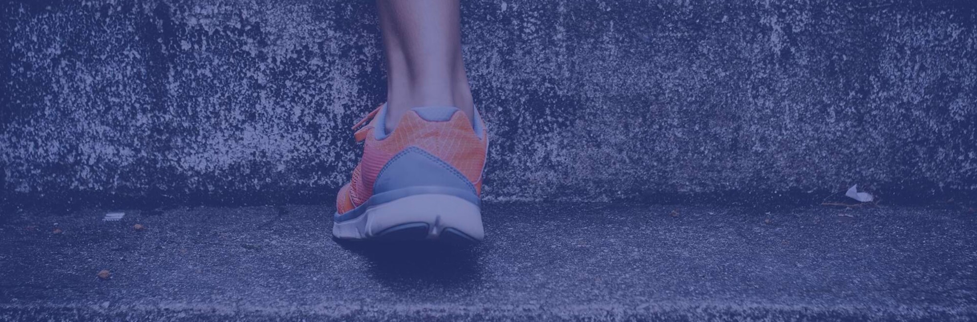 Detailaufnahme einer Person mit Sportschuhen, die die Treppe hinaufrennt