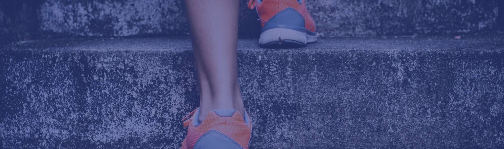 Detailaufnahme einer Person mit Sportschuhen, die die Treppe hinaufrennt