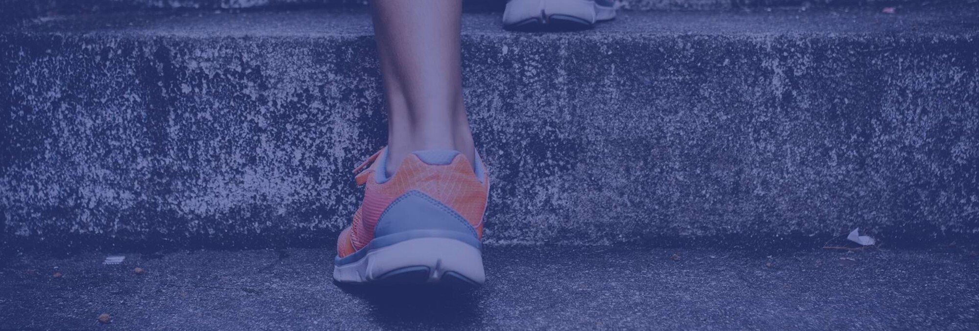 Detailaufnahme einer Person mit Sportschuhen, die die Treppe hinaufrennt