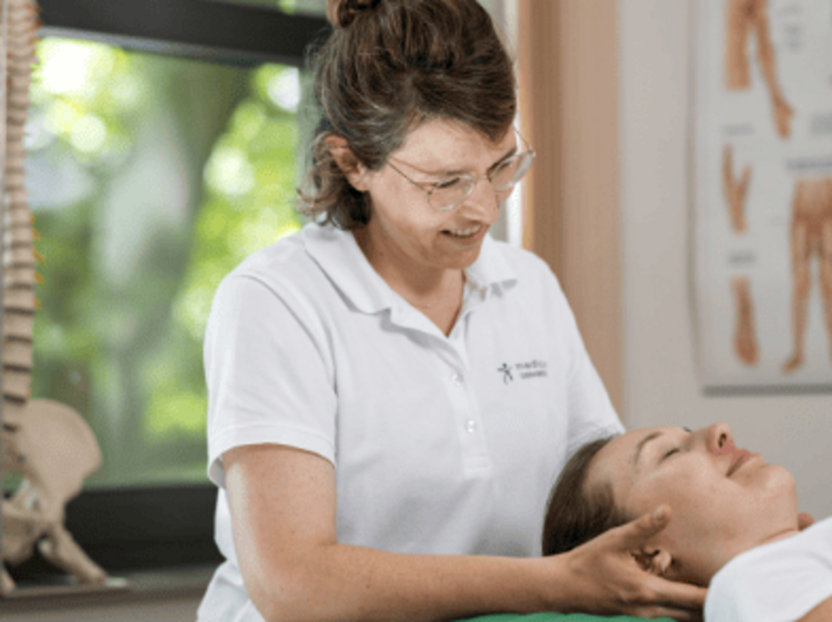Eine Therapeutin führt eine mobilisierende Technik am Kopf einer Patientin aus – stellvertretend für die individuelle Behandlung entzündlicher und stoffwechselbedingter Erkrankungen wie Rheuma oder Arthritis im medicos.Osnabrück.