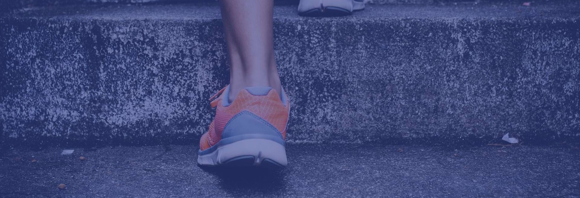 Detailaufnahme einer Person mit Sportschuhen, die die Treppe hinaufrennt